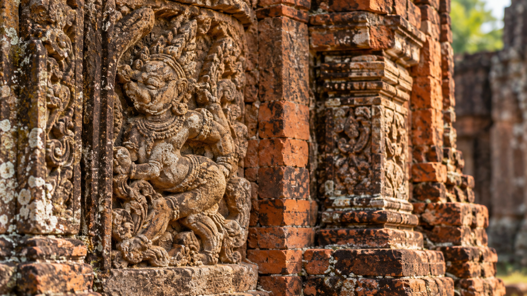 Close view of sandstone-style carved relief beside old Cham brickwork