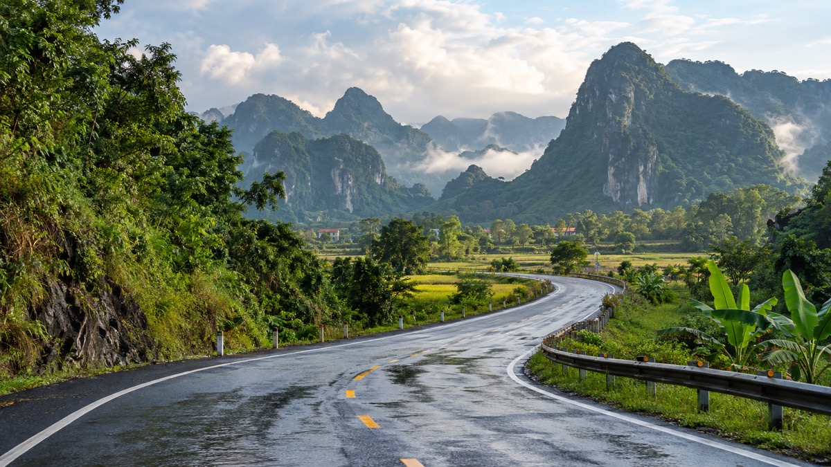 Road journey through green limestone countryside between Hue and Phong Nha